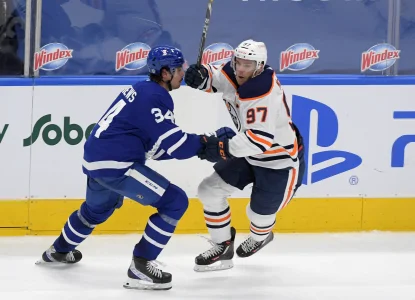Mar 29, 2021; Toronto, Ontario, CAN; Edmonton Oilers forward Connor McDavid (97) tries to skate past Toronto Maple Leafs forward Auston Matthews (34) in overtime at Scotiabank Arena.
