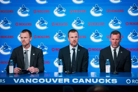 May 14, 2026; Vancouver, BC, Canada; Henrik Sedin and Ryan Johnson listen Daniel Sedin speak during a press conference where the Vancouver Canucks name new senior management staff. Henrik Sedin and his twin brother Daniel Sedin have been appointed as co-presidents of hockey operations and Ryan Johnson is now the new general manager of the club at Rogers Arena.