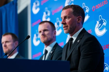 May 14, 2026; Vancouver, BC, Canada; Daniel Sedin listens to Ryan Johnson speak during a press conference where the Vancouver Canucks name new senior management staff. Henrik Sedin and his twin brother Daniel Sedin have been appointed as co-presidents of hockey operations and Ryan Johnson is now the new general manager of the club at Rogers Arena.