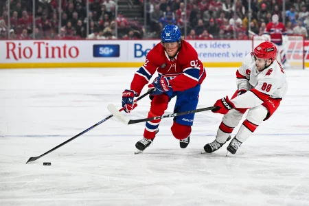 16 avril 2025; Montréal, Québec, Canada; Lailier droit des Canadiens de Montréal, Patrik Laine (92), joue la rondelle contre le défenseur des Hurricanes de la Caroline, Domenick Fensore (89), en première période au Centre Bell.