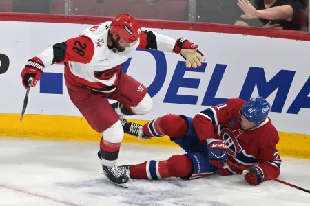 27 mai 2026; Montréal, Québec, Canada; lailier gauche des Hurricanes de la Caroline, William Carrier (28), met en échec le défenseur des Canadiens de Montréal, Kaiden Guhle (21), durant la troisième période du quatrième match de la finale de lAssociation de lEst des séries éliminatoires de la Coupe Stanley 2026 au Centre Bell.