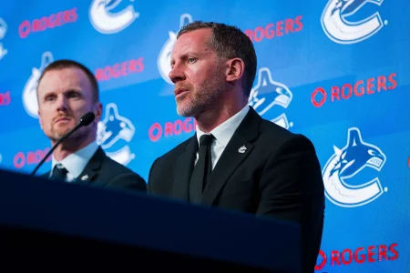 May 14, 2026; Vancouver, BC, Canada; Daniel Sedin listens to Ryan Johnson speak during a press conference where the Vancouver Canucks name new senior management staff. Henrik Sedin and his twin brother Daniel Sedin have been appointed as co-presidents of hockey operations and Ryan Johnson is now the new general manager of the club at Rogers Arena.