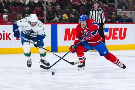 Jan 12, 2026; Montreal, Quebec, CAN; Montreal Canadiens right wing Brendan Gallagher (11) plays the puck against Vancouver Canucks defenseman Pierre-Olivier Joseph (7) during the second period at Bell Centre.