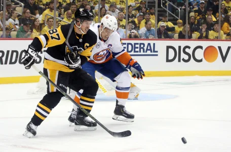 Dec 28, 2024; Elmont, New York, USA; Pittsburgh Penguins goaltender Tristan Jarry (35) makes a save in front of New York Islanders left wing Anders Lee (27) and Penguins center Sidney Crosby (87) during the second period at UBS Arena.