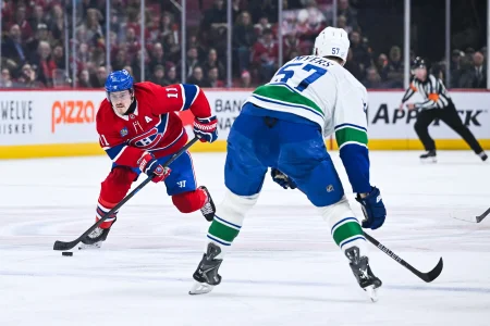 12 janvier 2026; Montréal, Québec, Canada; lailier droit des Canadiens de Montréal, Brendan Gallagher (11), joue la rondelle contre le défenseur des Canucks de Vancouver, Tyler Myers (57), durant la deuxième période au Centre Bell.