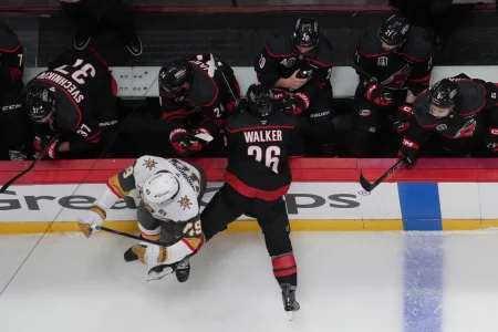 Jun 2, 2026; Raleigh, North Carolina, USA; Vegas Golden Knights left wing Ivan Barbashev (49) checks Carolina Hurricanes defenseman Sean Walker (26) into the bench during the first period in game one of the 2026 Stanley Cup Final at Lenovo Center.