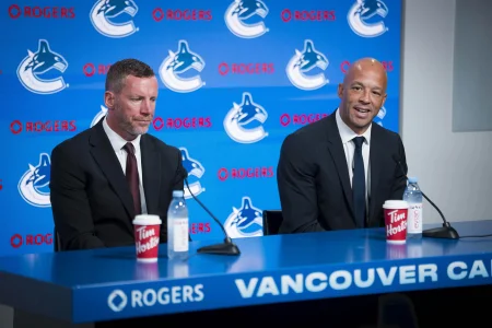 Jun 4, 2026; Vancouver, BC, CANADA; General manager Ryan Johnson listens to Manny Malhotra speak during press conference where the Vancouver Canucks introduce Malhotra as their new head coach during a press conference at Rogers Arena.