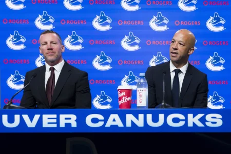 Jun 4, 2026; Vancouver, BC, CANADA; General manager Ryan Johnson listens to Manny Malhotra speak during press conference where the Vancouver Canucks introduce Malhotra as their new head coach during a press conference at Rogers Arena