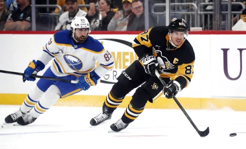 Oct 16, 2024; Pittsburgh, Pennsylvania, USA; Pittsburgh Penguins center Sidney Crosby (87) skates with the puck ahead of Buffalo Sabres right wing Alex Tuch (89) during the first period against at PPG Paints Arena.