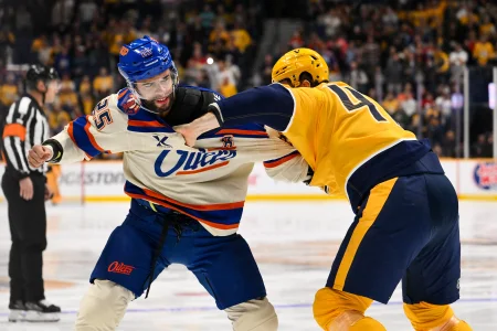 Jan 13, 2026; Nashville, Tennessee, USA; Edmonton Oilers defenseman Darnell Nurse (25) and Nashville Predators right wing Michael McCarron (47) exchange punches during the first period at Bridgestone Arena.