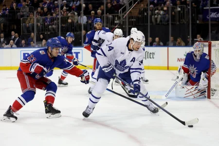 Dec 15, 2022; New York, New York, USA; Toronto Maple Leafs center Auston Matthews (34) controls the puck against New York Rangers defenseman Adam Fox (23) and goaltender Igor Shesterkin (31) during the first period at Madison Square Garden.