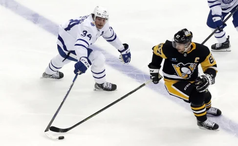 Nov 26, 2022; Pittsburgh, Pennsylvania, USA; Toronto Maple Leafs center Auston Matthews (34) and Pittsburgh Penguins center Sidney Crosby (87) reach for the puck during the third period at PPG Paints Arena. Toronto won 4-1.