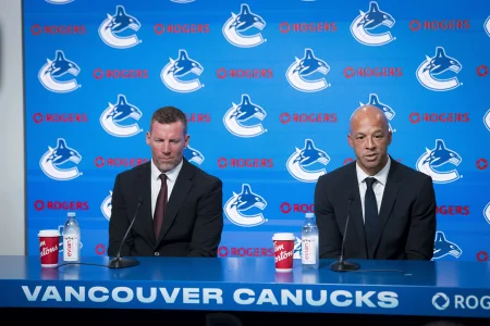 Jun 4, 2026; Vancouver, BC, CANADA; General manager Ryan Johnson listens to Manny Malhotra speak during press conference where the Vancouver Canucks introduce Malhotra as their new head coach during a press conference at Rogers Arena. Jun 4, 2026; Vancouver, BC, CANADA; General manager Ryan Johnson listens to Manny Malhotra speak during press conference where the Vancouver Canucks introduce Malhotra as their new head coach during a press conference at Rogers Arena.
