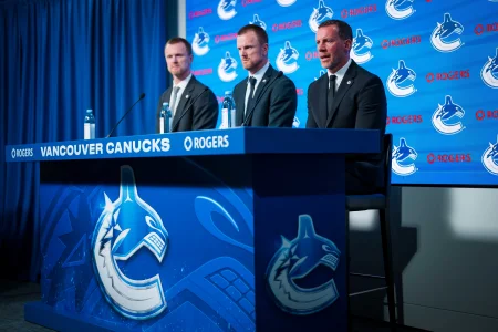 May 14, 2026; Vancouver, BC, Canada; Henrik Sedin and Daniel Sedin listen to Ryan Johnson speak during a press conference where the Vancouver Canucks name new senior management staff. Henrik Sedin and his twin brother Daniel Sedin have been appointed as co-presidents of hockey operations and Ryan Johnson is now the new general manager of the club at Rogers Arena.