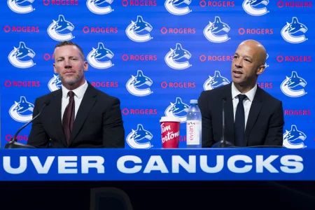 Jun 4, 2026; Vancouver, BC, CANADA; General manager Ryan Johnson listens to Manny Malhotra speak during press conference where the Vancouver Canucks introduce Malhotra as their new head coach during a press conference at Rogers Arena.