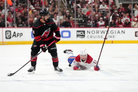 29 mai 2026 ; Raleigh, Caroline du Nord, États-Unis ; Seth Jarvis (24), centre des Hurricanes de la Caroline, joue la rondelle face à Cole Caufield (13), ailier droit des Canadiens de Montréal, lors du cinquième match de la finale de lAssociation de lEst des séries éliminatoires de la Coupe Stanley 2026, durant la première période au Lenovo Center.