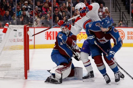 21 décembre 2022; Denver, Colorado, États-Unis; le centre des Canadiens de Montréal, Kirby Dach (77), tente de dévier la rondelle face au gardien de but de lAvalanche du Colorado, Alexandar Georgiev (40), tandis que le centre Alex Newhook (18) défend, en première période à la Ball Arena.