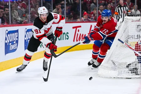 5 avril 2026; Montréal, Québec, Canada; Dawson Mercer (91), centre des Devils du New Jersey, joue la rondelle face à Arber Xhekaj (72), défenseur des Canadiens de Montréal, durant la deuxième période au Centre Bell.