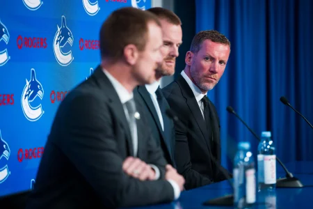 May 14, 2026; Vancouver, BC, Canada; Ryan Johnson and Daniel Sedin listen to Henrik Sedin speak during a press conference where the Vancouver Canucks name new senior management staff. Henrik Sedin and his twin brother Daniel Sedin have been appointed as co-presidents of hockey operations and Ryan Johnson is now the new general manager of the club at Rogers Arena