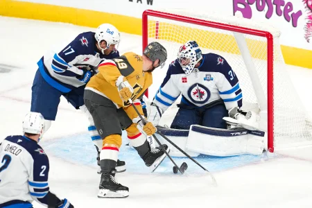 Apr 13, 2026; Las Vegas, Nevada, USA; Winnipeg Jets center Adam Lowry (17) breaks up a scoring chance by Vegas Golden Knights left wing Ivan Barbashev (49) as goaltender Connor Hellebuyck (37) defends his net during the third period at T-Mobile Arena.