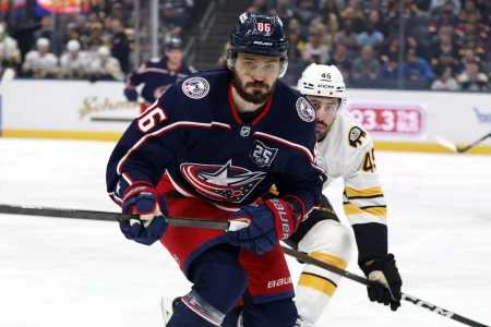 Apr 12, 2026; Columbus, Ohio, USA; Columbus Blue Jackets right wing Kirill Marchenko (86) and Boston Bruins defenseman Jonathan Aspirot (45) skate after a loose puck during the first period at Nationwide Arena.