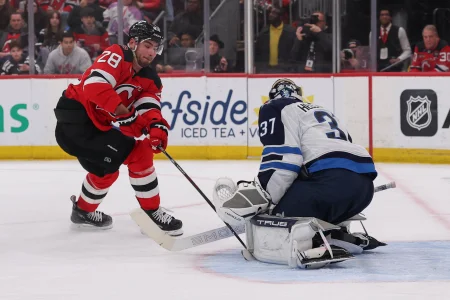 Jan 27, 2026; Newark, New Jersey, USA; Winnipeg Jets goaltender Connor Hellebuyck (37) makes a save on New Jersey Devils right wing Timo Meier (28) during the second period at Prudential Center.