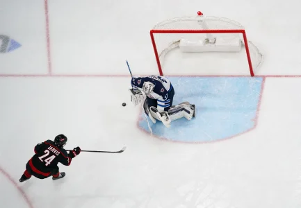 Mar 9, 2025; Raleigh, North Carolina, USA; Winnipeg Jets goaltender Connor Hellebuyck (37) stops the scoring attempt by Carolina Hurricanes center Seth Jarvis (24) during the second period at Lenovo Center.