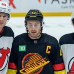The Hughes brothers all pose for a photo as the New Jersey Devils take on the Vancouver Canucks