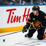 Jan 3, 2026; Vancouver, British Columbia, CAN; Vancouver Canucks forward Kiefer Sherwood (44) reaches for the loose puck against the Boston Bruins in the second period at Rogers Arena.