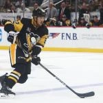 Oct 21, 2025; Pittsburgh, Pennsylvania, USA; Pittsburgh Penguins defenseman Caleb Jones (82) handles the puck against the Vancouver Canucks during the third period at PPG Paints Arena.
