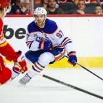 Feb 4, 2026; Calgary, Alberta, CAN; Edmonton Oilers center Connor McDavid (97) controls the puck against the Calgary Flames during the third period at Scotiabank Saddledome. Mandatory Credit: Sergei Belski-Imagn Images