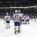 May 10, 2024; Vancouver, British Columbia, CAN; Edmonton Oilers forward Mattias Janmark (13) and forward Leon Draisaitl (29) and forward Connor McDavid (97) celebrate their victory against the Vancouver Canucks during the first overtime in game two of the second round of the 2024 Stanley Cup Playoffs at Rogers Arena. Mandatory Credit: Bob Frid-Imagn Images