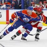 Mar 6, 2026; Edmonton, Alberta, CAN; Edmonton Oilers forward Connor McDavid (97) protects the puck from Carolina Hurricanes defensemen Jalen Chatfield (5) during the third period at Rogers Place. Mandatory Credit: Perry Nelson-Imagn Images