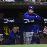 Jun 22, 2021; San Diego, California, USA; Los Angeles Dodgers starting pitcher Trevor Bauer (top) looks on from the dugout during the fifth inning against the San Diego Padres at Petco Park. Mandatory Credit: Orlando Ramirez-Imagn Images