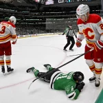 Apr 7, 2026; Dallas, Texas, USA; Calgary Flames center Ryan Strome (22) stands over Dallas Stars left wing Jason Robertson (21) after Strome draws a four minute penalty for high sticking during the overtime period at the American Airlines Center. Mandatory Credit: Jerome Miron-Imagn Images