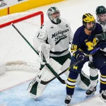 Michigan State goaltender Trey Augustine (1), left, tends net against Michigan forward Michael Hage (19) during the second period of Duel in the D at Little Caesars Arena in Detroit on Saturday, February 7, 2026.