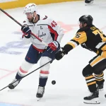 Apr 11, 2026; Pittsburgh, Pennsylvania, USA; A puck bounces between Washington Capitals lright wing Tom Wilson (43) and Pittsburgh Penguins defenseman Connor Clifton (75) during the first period at PPG Paints Arena. Mandatory Credit: Philip G. Pavely-Imagn Images