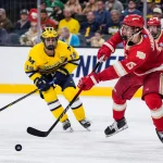 Denver defenseman Eric Jamieson (15) passes the puck against Michigan forward Michael Hage (19) during the third period of the Frozen Four semifinal at T-Mobile Arena in Las Vegas on Thursday, April 9, 2026