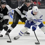 Mar 29, 2025; Los Angeles, California, USA; Los Angeles Kings defenseman Joel Edmundson (6) and Toronto Maple Leafs left wing Scott Laughton (24) vie for the puck in the first period at Crypto.com Arena. Mandatory Credit: Jayne Kamin-Oncea-Imagn Images