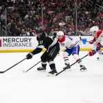Mar 7, 2026; Los Angeles, California, USA; Los Angeles Kings center Anze Kopitar (11) looks to shoot the puck while under pressure from Montréal Canadiens defensemen Lane Hutson (48) and Noah Dobson (53) during the second period at Crypto.com Arena. Mandatory Credit: William Liang-Imagn Images