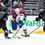 Mar 12, 2026; Seattle, Washington, USA; Colorado Avalanche forward Nathan MacKinnon (29) skates against Seattle Kraken forward Frederick Gaudreau (89) and defenseman Adam Larsson (6) during the first period at Climate Pledge Arena.