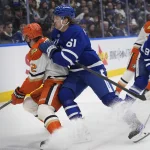 Mar 12, 2026; Toronto, Ontario, CAN; Toronto Maple Leafs forward Michael Pezzetta (61) checks Anaheim Ducks defenseman Jackson LaCombe (2) during the third period at Scotiabank Arena. Mandatory Credit: John E. Sokolowski-Imagn Images