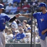 Feb. 25, 2026: Toronto Blue Jays rookie Kazuma Okamoto (Left) fist bumps hitting coach David Popkins (Right) after scoring on an RBI single by Nathan Lukes in the fourth inning of a spring training baseball game against the Detroit Tigers in Lakeland, Florida.