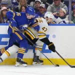Apr 19, 2026; Buffalo, New York, USA; Boston Bruins center Mark Kastelic (47) tries to control the puck as Buffalo Sabres defenseman Rasmus Dahlin (26) defends during the third period in game one of the first round of the 2026 Stanley Cup Playoffs at KeyBank Center.