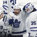 Jan 17, 2026; Winnipeg, Manitoba, CAN; Toronto Maple Leafs left wing Nicholas Robertson (89), Matias MacCelli (63) and goaltender Dennis Hildeby (35) celebrate their victory over the Winnipeg Jets at Canada Life Centre. Mandatory Credit: James Carey Lauder-Imagn Images