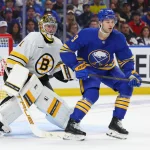 Apr 21, 2026; Buffalo, New York, USA; Boston Bruins goaltender Jeremy Swayman (1) and Buffalo Sabres center Josh Norris (9) look for the puck during the second period in game two of the first round of the 2026 Stanley Cup Playoffs at KeyBank Center. Mandatory Credit: Timothy T. Ludwig-Imagn Images