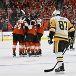 Apr 22, 2026; Philadelphia, Pennsylvania, USA; Philadelphia Flyers right wing Owen Tippett (74) celebrates his empty goal with teammates against Pittsburgh Penguins center Sidney Crosby (87) during the third period in game three of the first round of the 2026 Stanley Cup Playoffs at Xfinity Mobile Arena.