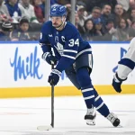 Mar 7, 2026; Toronto, Ontario, CAN; Toronto Maple Leafs forward Auston Matthews (34) carries the puck up ice against Tampa Bay Lightning forward Yanni Gourde (37) in the first period at Scotiabank Arena. Mandatory Credit: Dan Hamilton-Imagn Images