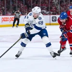 Apr 26, 2026; Montreal, Quebec, CAN; Tampa Bay Lightning center Jake Guentzel (59) plays the puck against Montreal Canadiens center Alex Newhook (15) during the second period in game four of the first round of the 2026 Stanley Cup Playoffs at Bell Centre.