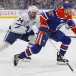 Feb 3, 2026; Edmonton, Alberta, CAN; Edmonton Oilers forward Connor McDavid (97) carries the puck around Toronto Maple Leafs forward Auston Matthews (34) during the first period at Rogers Place. Mandatory Credit: Perry Nelson-Imagn Images